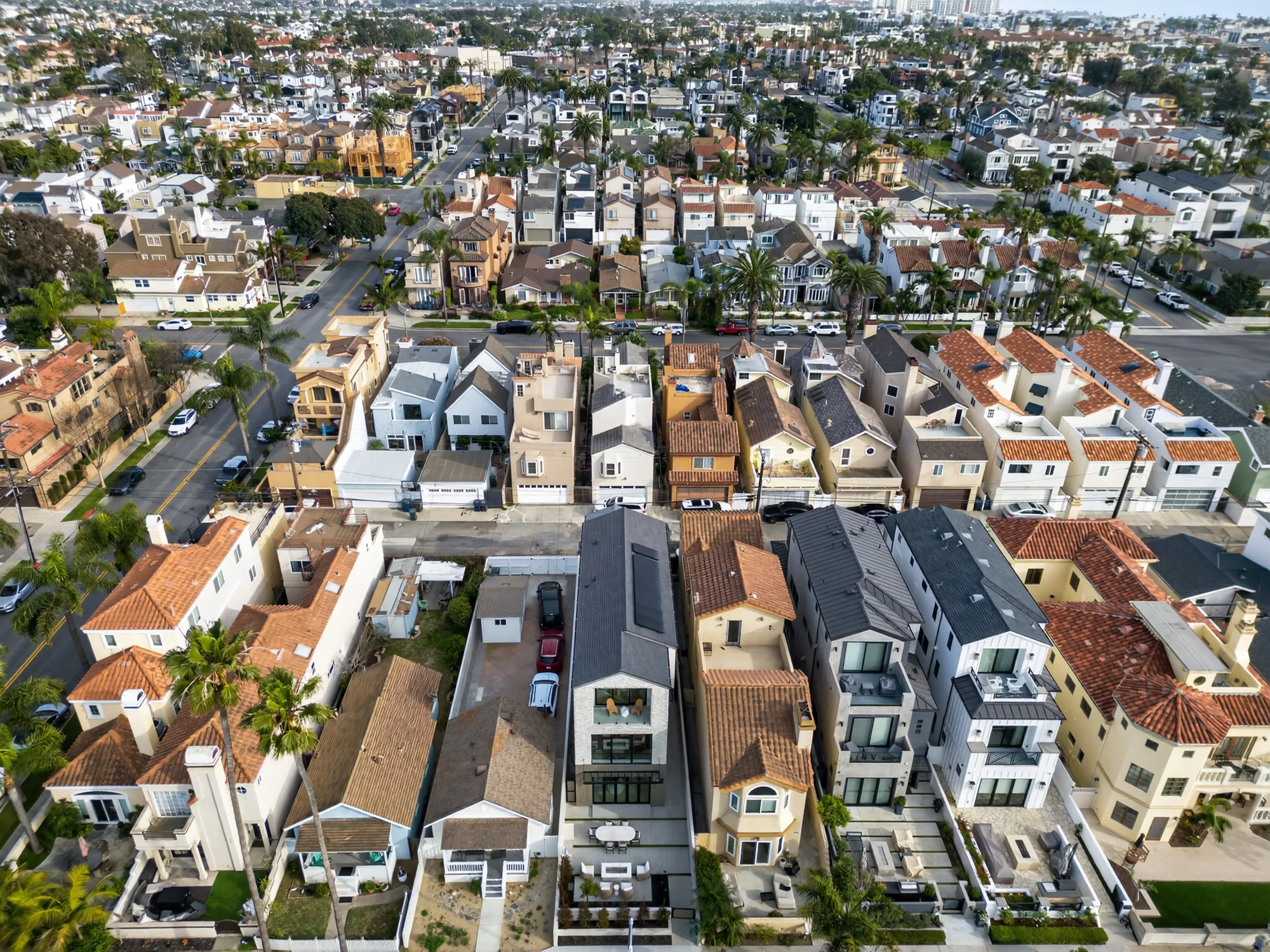 Wide aerial drone photo of dense coastal beach-town neighborhood