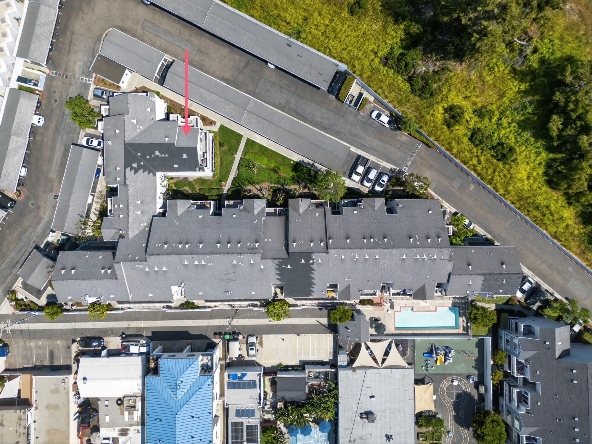 Overhead drone photo of multi-unit complex with property location arrow