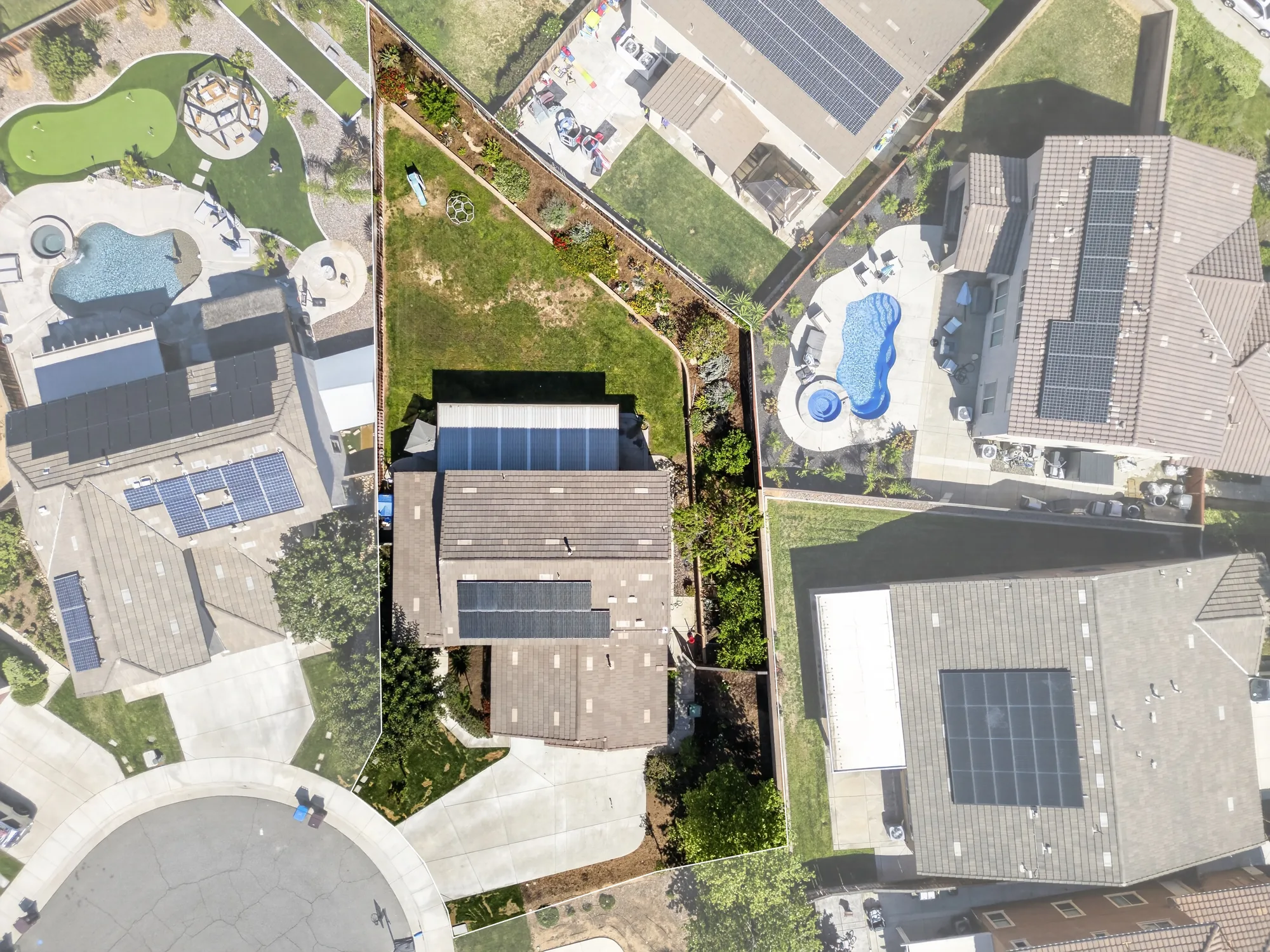 Overhead drone photo of cul-de-sac home with property outline and neighboring pools