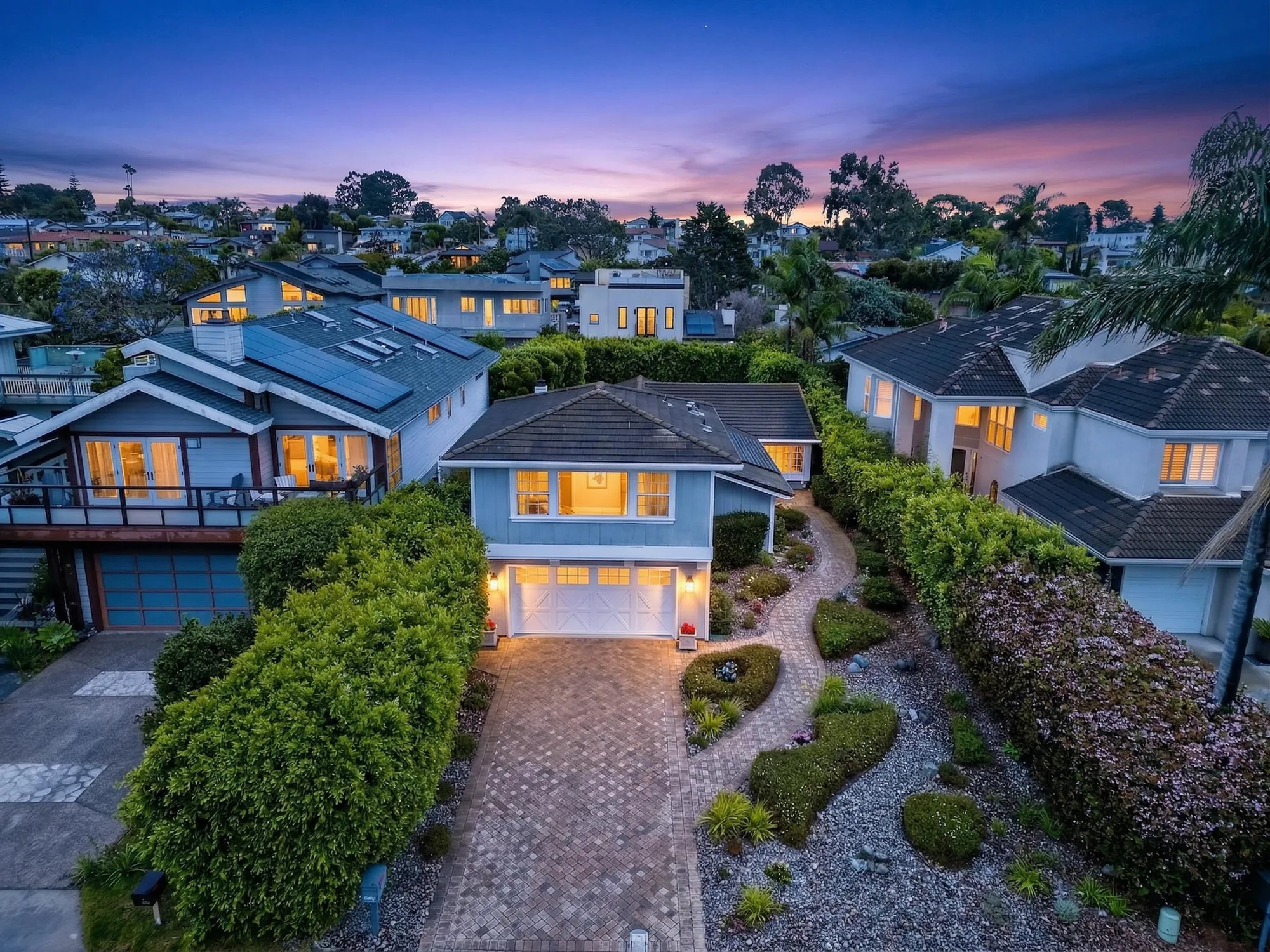 Twilight aerial drone photo of coastal-style luxury home