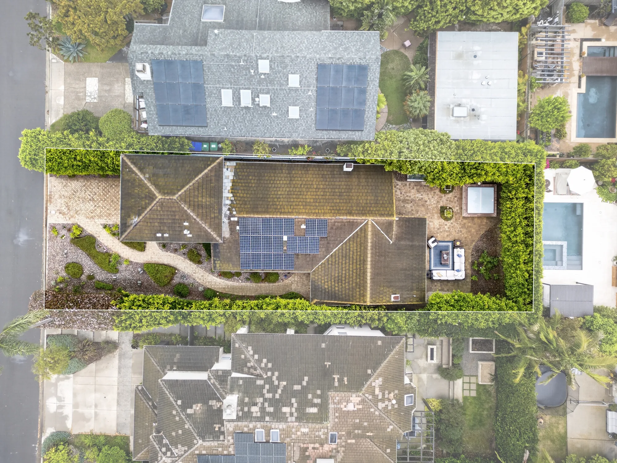 Overhead drone shot of home with solar panels hot tub and property line outline
