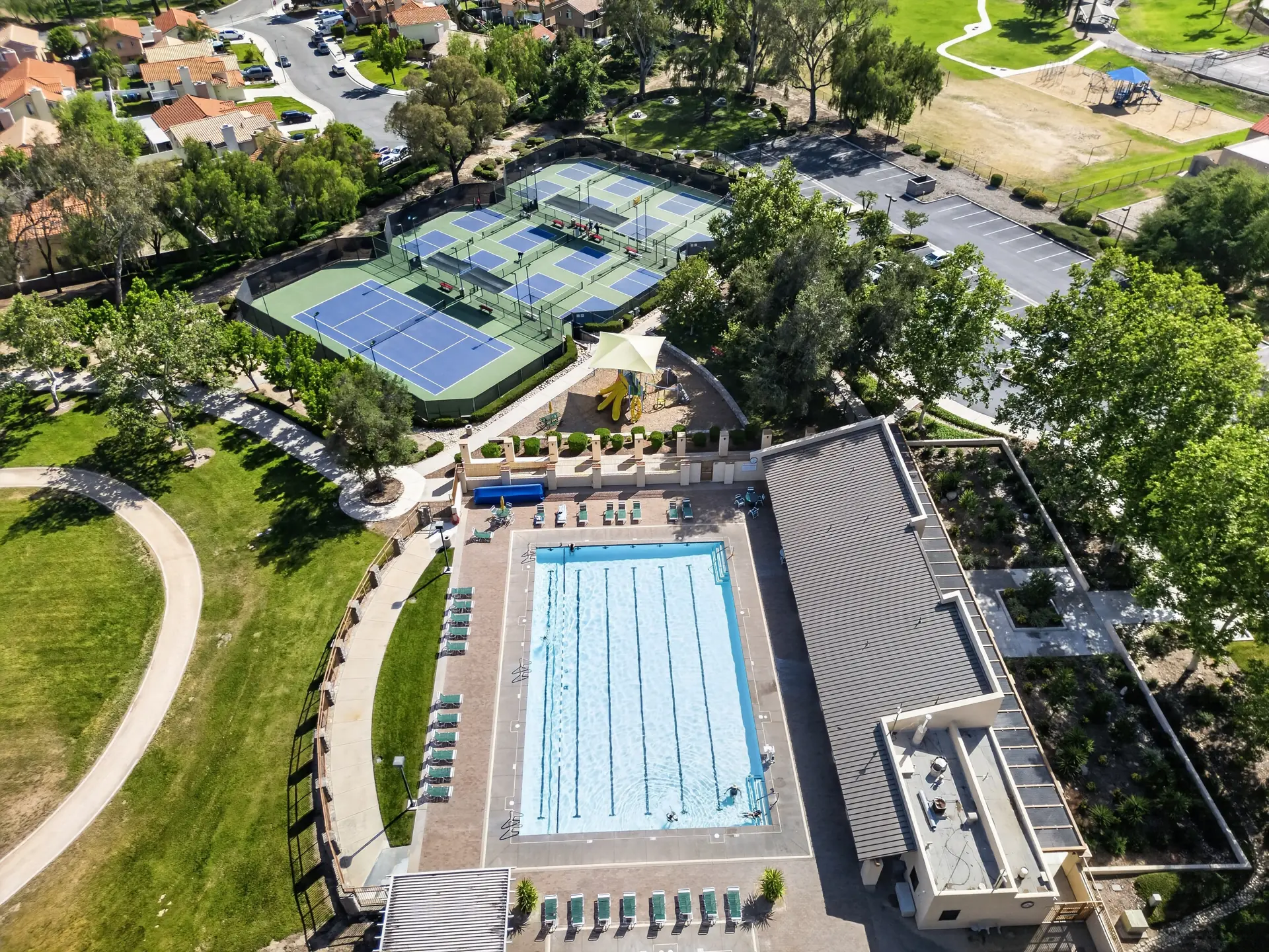 Aerial drone photo of community pool tennis courts and recreation hub