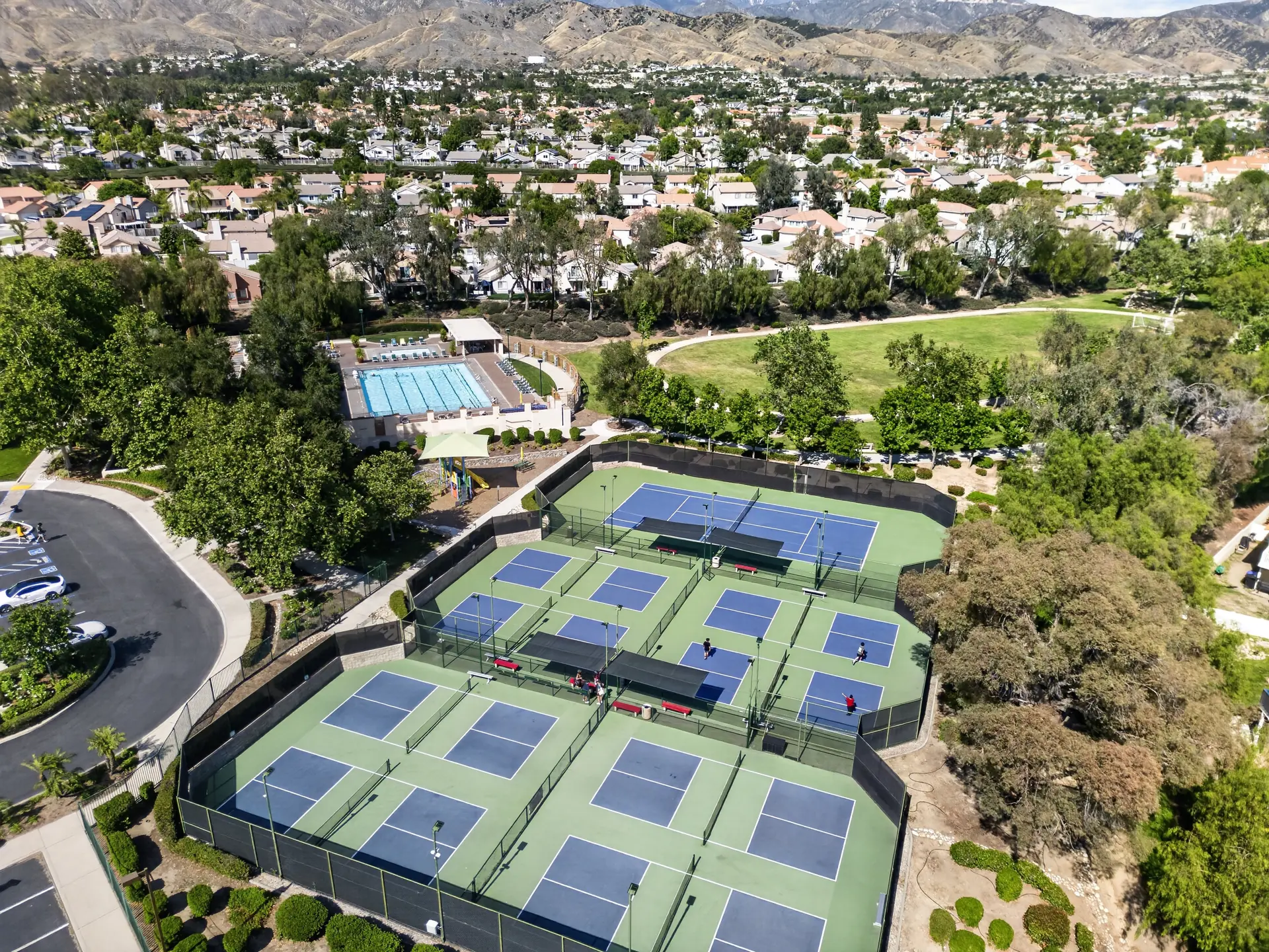 Aerial drone photo of HOA tennis and pickleball facility with pool