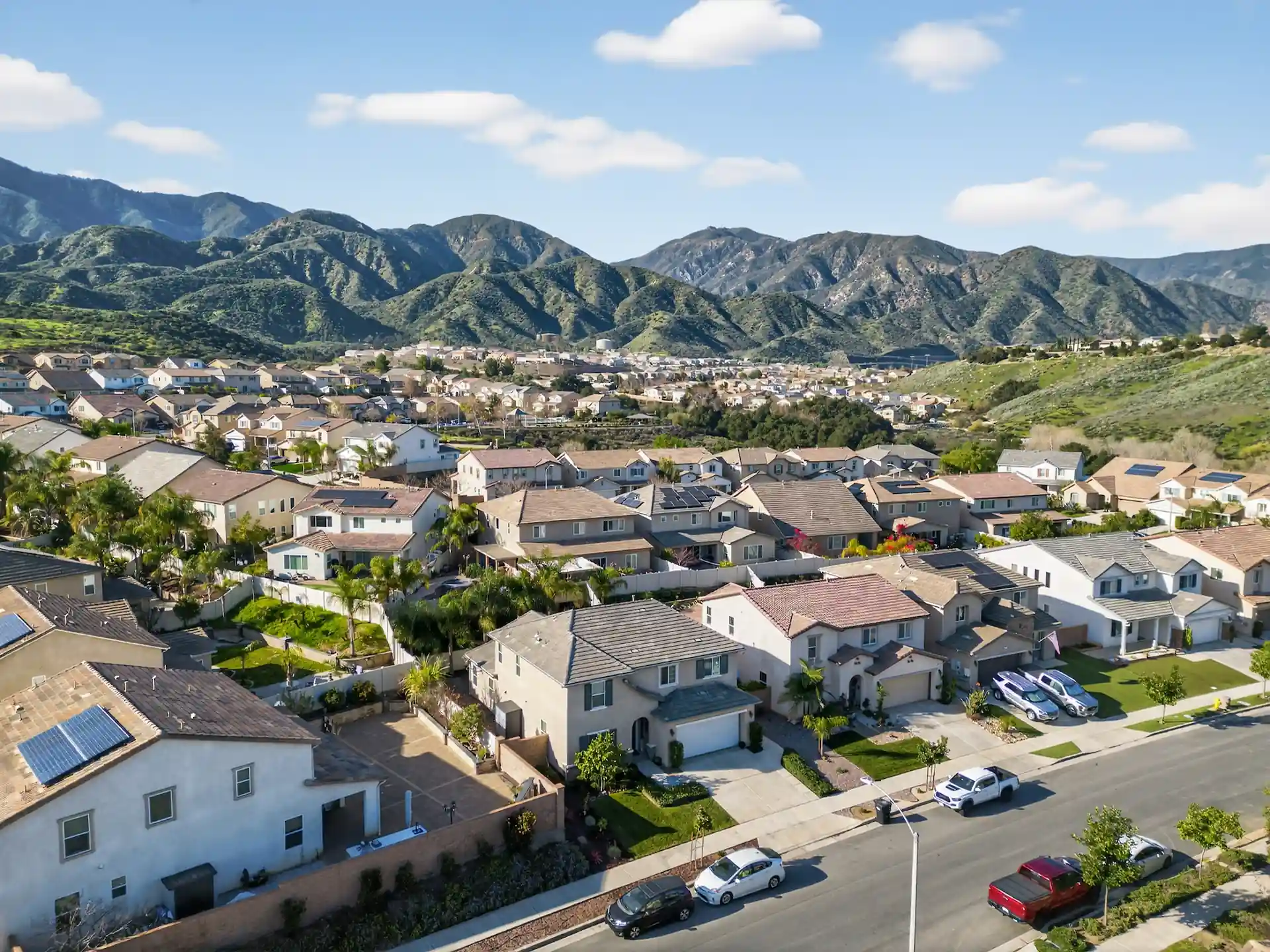 Wide aerial drone photo of Inland Empire residential neighborhood with mountain views