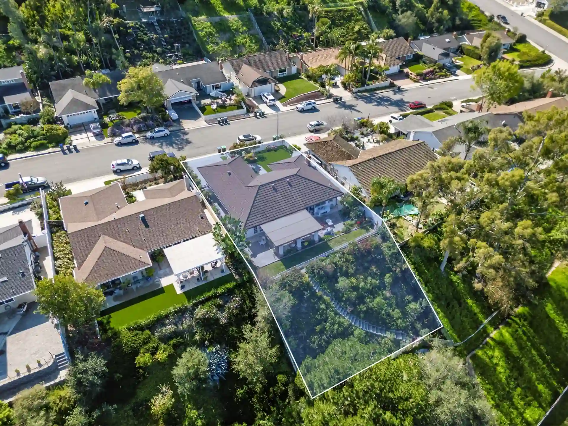 Aerial drone photo with property boundary overlay on single-story home